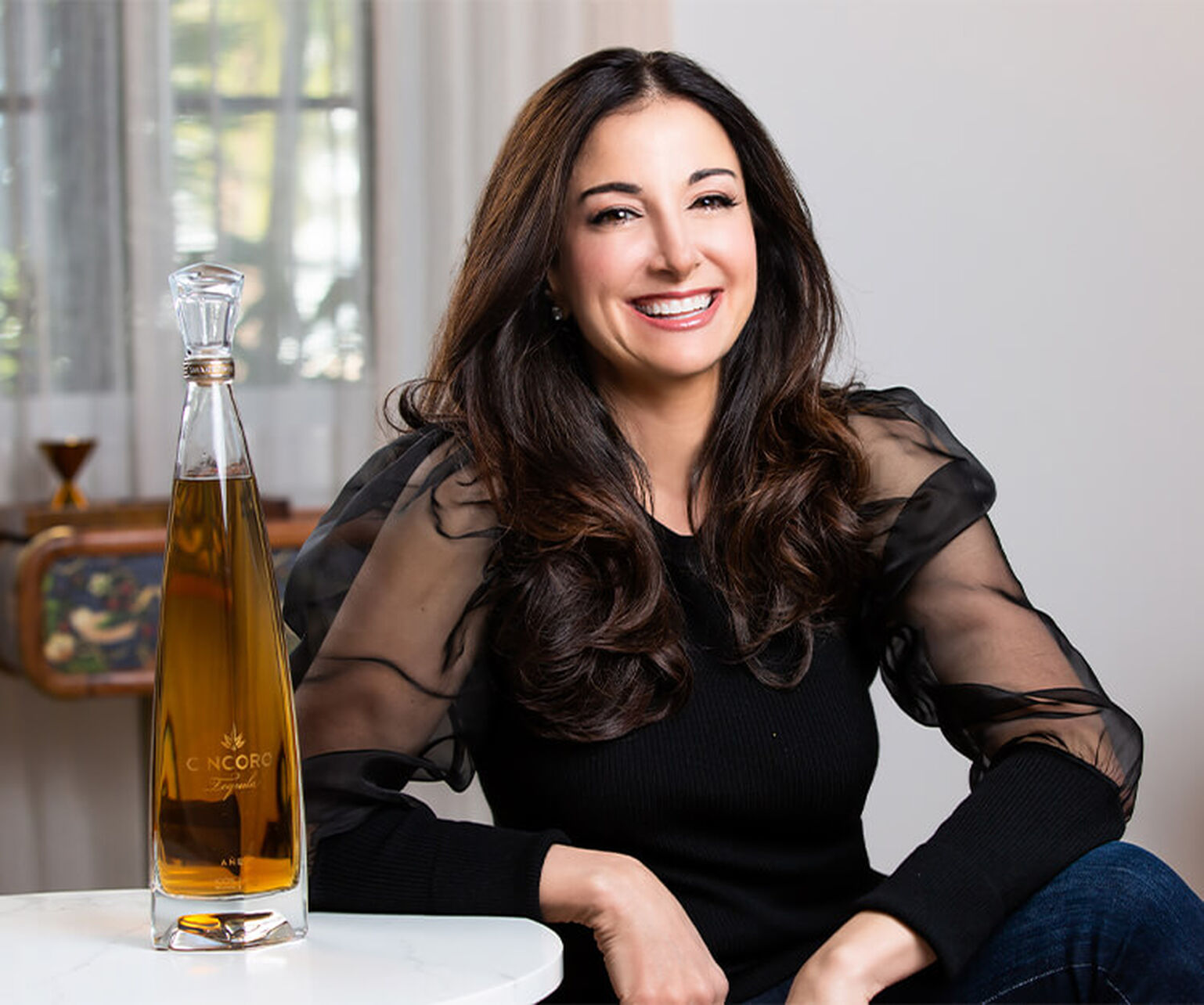 Emilia Fazzalari smiles as she sits next to a bottle of Cincoro